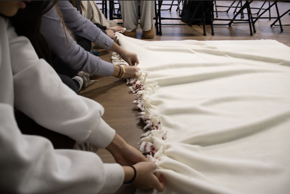 DOGGY DUVETS: As UNICEF students work through the winter, one of their most recent projects included creating blankets for dogs currently housed in a local shelter. The students cut strips into each side of the giant blanket sheet before tying the stripes together for a knotted effect. The blankets will be sent to Heartland Animal shelter, a local shelter that often works with different clubs at South. 